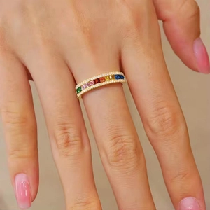 Macro shot of gold eternity ring with multi-colored baguette stones and pave diamonds