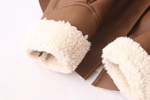 Gros plan de la texture du cuir marron et de la doublure en peau lainée blanche au poignet