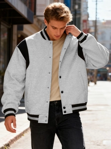 Detail of grey varsity jacket with black contrast raglan sleeves and striped ribbing cuffs
