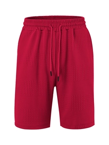 Detail showing red waffle knit fabric texture and drawstring elastic waistband on shorts