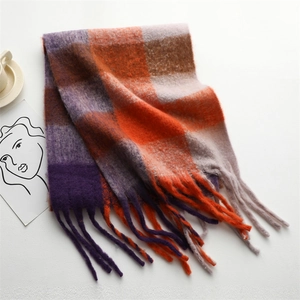 Detail of soft rainbow plaid scarf featuring thick tassels and fuzzy knitted texture