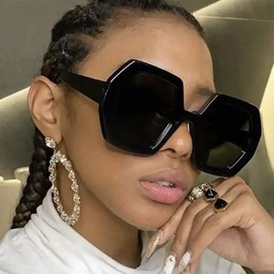 Fashionable oversized black polygonal sunglasses paired with silver rhinestone hoop earrings