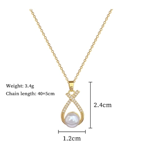 Detail shot of gold necklace dimensions featuring pearl and rhinestone cross pendant