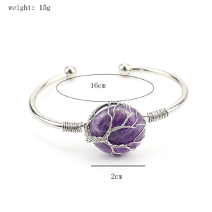 Macro detail of wire-wrapped tree of life design on purple crystal stone cuff bracelet