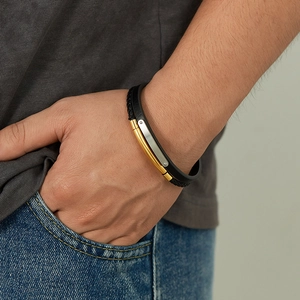 Gros plan d'un bracelet en cuir tressé double couche avec fermoir en métal doré et argenté