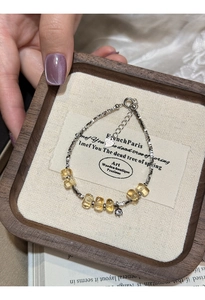 Detail of S925 sterling silver bracelet with yellow citrine beads and heart tag