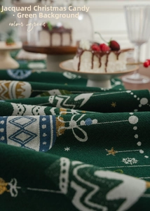 Close-up of green jacquard Christmas table runner featuring festive candy patterns