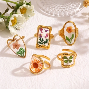 Golden stainless steel rings with preserved real flowers embedded in resin settings