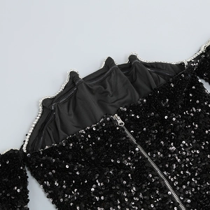 Détail de la robe noire à paillettes avec bordure en strass et fermeture éclair au dos
