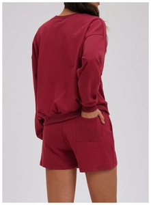 Detailed back view of dark red knit sweatshirt and drawstring shorts on a model