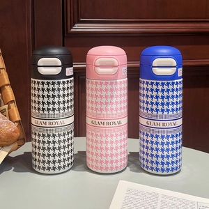 Close-up of three houndstooth thermal bottles in black, pink, and blue with GLAM ROYAL logo