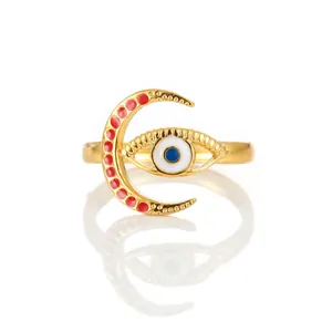 Detailed macro of gold crescent moon ring with red enamel and blue evil eye charm