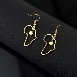 Vue macro détaillée des boucles d'oreilles carte d'Afrique dorées avec pendentifs cœur