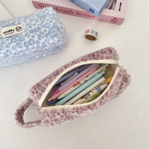 Close-up of leopard print plush cosmetic pouches showing interior storage and soft texture