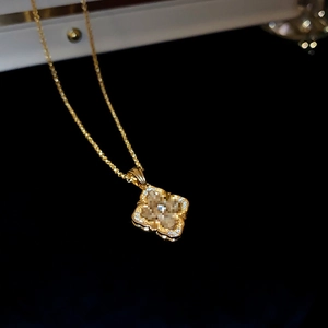 Detail of a vintage gold-plated necklace with a diamond-encrusted flower pendant on black back