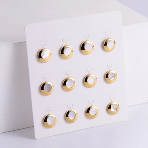 Set of 12 elegant round gold-plated shell earrings arranged on a white display card