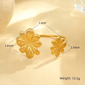 Detail of gold floral open bangle showing brushed metal texture and precise dimensions