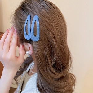 Close-up of blue denim texture drop-shaped hair clips on model side hair