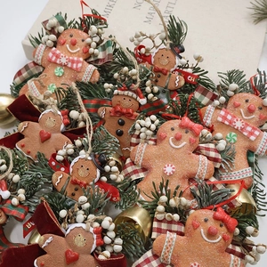 Handmade Christmas gingerbread man hanging ornament with pine needles and golden bell