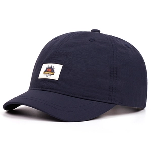 Close-up view of dark blue short brim quick-dry baseball cap with camping adventure patch