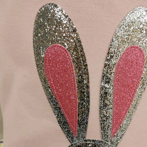 Detail of pink canvas storage bin featuring glittery rabbit ears with silver sequins