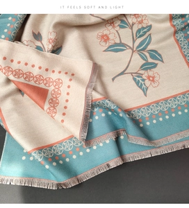 Detail of floral cashmere scarf with fringe edges and star patterns on dark background