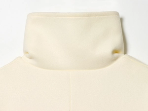 Close-up of stand collar and soft wool texture on cream women's fashion coat