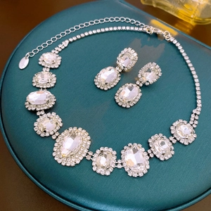 Elegant silver oval pendant necklace and earrings set with shimmering crystals