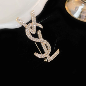 Detailed macro view of the gold-toned metal brooch with encrusted sparkling crystals
