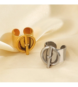 Detail of gold and silver stainless steel rings with T-bar design on silk fabric