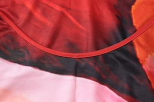 Macro detail of U-neckline with double-needle stitching on colorful abstract print fabric
