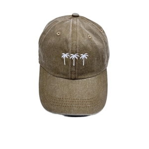 Detail of white palm tree embroidery on retro washed khaki cotton baseball cap