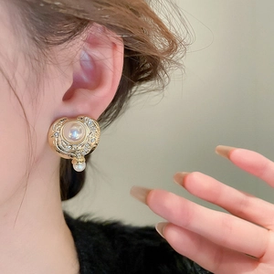 Orecchini vintage stile corte francese in metallo dorato con perle e strass su una modella