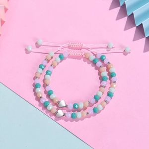 Détail de bracelets en perles de cristal colorées avec pendentifs cœur et cordon ajustable
