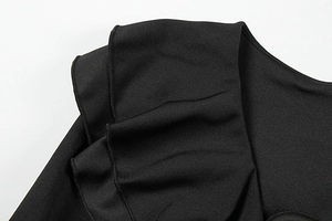 Détail rapproché des volants multicouches sur la robe noire avec coutures de qualité
