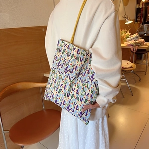 Sac cabas en toile à fleurs avec motifs tulipes et lanières jaunes dans un café cosy