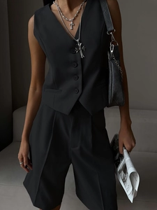 Detailed view of the V-neck single-breasted black suit vest and its textured fabric