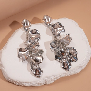 Exaggerated silver metallic petal drop earrings with polished mirror finish on stone tray