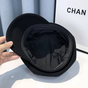 Detail view showing black octagonal newsboy hat interior with lining and sweatband