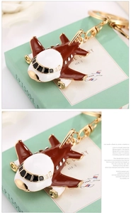 Detail of red aircraft keychain with rhinestones and gold-tone metal plating