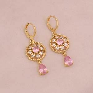 Close-up of gold flower earrings with pink crystal drop and cubic zirconia petals
