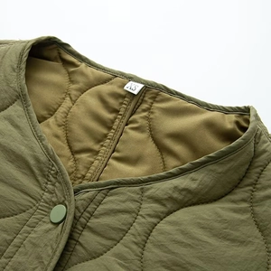 Detailaufnahme der armeegrünen Steppjacke mit Zwiebelsteppmuster und Druckknopf-Verschluss