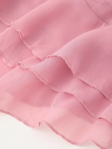 Detail eines rosa Chiffonkleides mit Rüschenkanten und feiner Overlock-Nahtverarbeitung