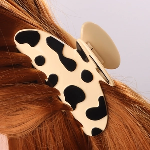 Pince à cheveux motif vache pour coiffure féminine sur de longs cheveux roux