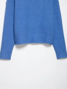 Détail des poignets côtelés sur un pull en maille bleue à texture douce
