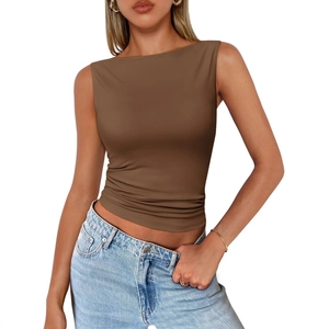 Top senza maniche marrone aderente in maglia da donna con jeans chiari su sfondo bianco