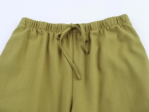 Detail of elastic waist with matching drawstring on olive green linen trousers