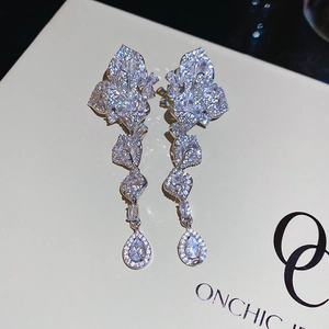 Macro view of silver leaf-shaped drop earrings with micro-pave zircons and waterdrop pendant