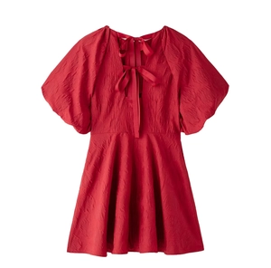 Vue détaillée de la robe rouge à manches bouffantes avec dos nu et nœuds élégants