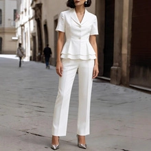 Dettaglio di blazer bianco con peplo e pantaloni a vita alta in una strada europea